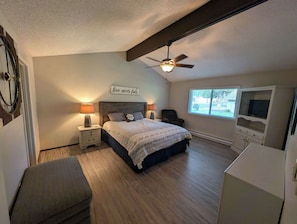 A bedroom with a bed, nightstands, a ceiling fan, a window, and a TV. - Pondy - 101 Ponderosa (Plumas Eureka)