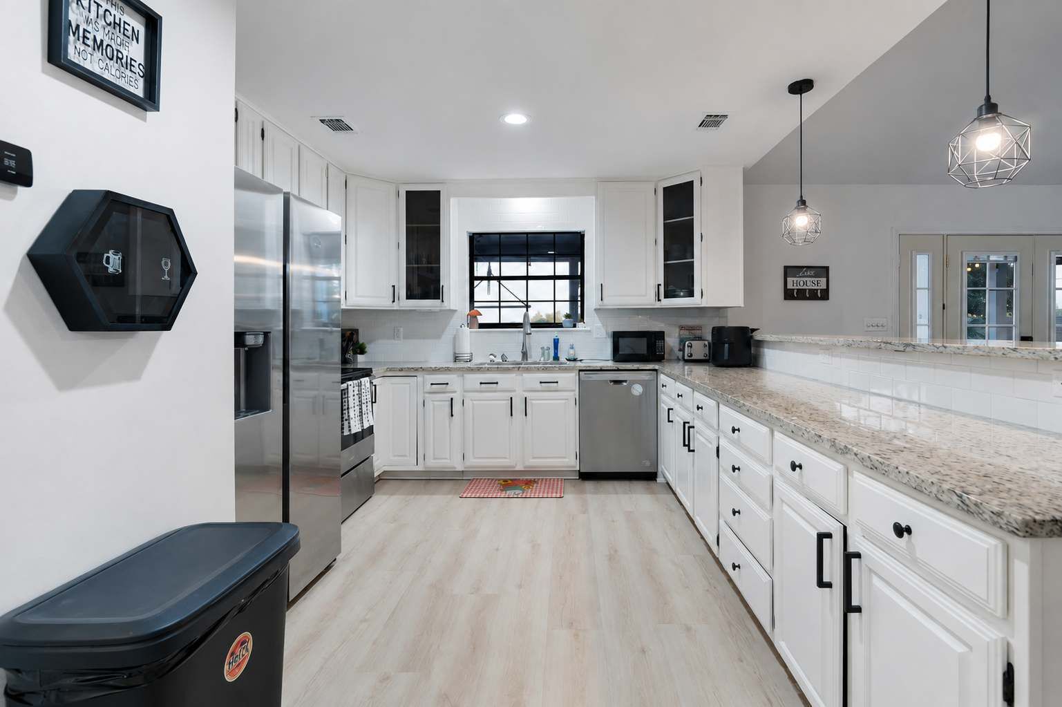 A modern kitchen with white cabinetry, stainless steel appliances, and a granite countertop.