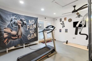A gym with a treadmill, a wall with motivational posters, and a banner with a muscular arm illustration.