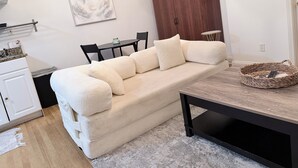 Una sala moderna con un sofá, una mesa de comedor y un mueble de madera.