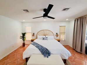 A bedroom with a bed, a ceiling fan, a window with blinds, a potted plant, and a curtain. - Waterfront Oasis: A peaceful escape in Cape Coral (Cape Coral)