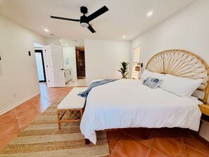 A bedroom with a bed, a ceiling fan, a bedside table, and a nightstand. - Waterfront Oasis: A peaceful escape in Cape Coral (Cape Coral)
