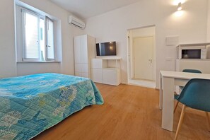 A room with a bed, a desk, a chair, a television, and a wardrobe. - The Two Olive Trees - North (Campo nell'Elba)