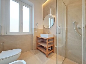 Ein modernes Badezimmer mit Toilette, Waschbecken und Dusche.