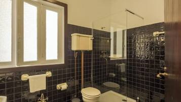 A bathroom with a toilet, bidet, and bathtub.
