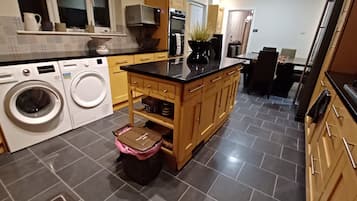 A kitchen with a washing machine, a sink, and a stove.