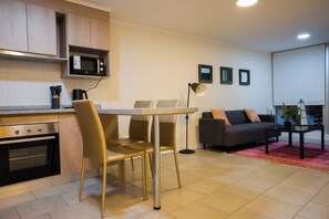 A compact living space with a kitchenette, dining area, and seating.