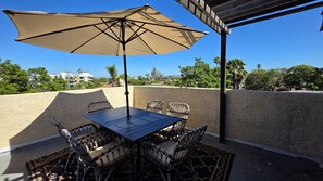 An outdoor patio with a table and chairs, a large umbrella, and a view of the surrounding area. - Stylish 2 bedroom + loft with rooftop patio and views near Beverly Hills (Beverly Hills)