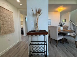 A dining area with a table and chairs, a vase with dried plants, and a wall-mounted macrame piece. - Stylish 2 bedroom + loft with rooftop patio and views near Beverly Hills (Beverly Hills)