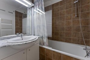 Ein Badezimmer mit einer Badewanne, einem Waschbecken und einer Dusche.