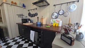 Une cuisine avec un carrelage à motifs, un plan de travail en bois, ainsi que divers ustensiles et appareils de cuisine.