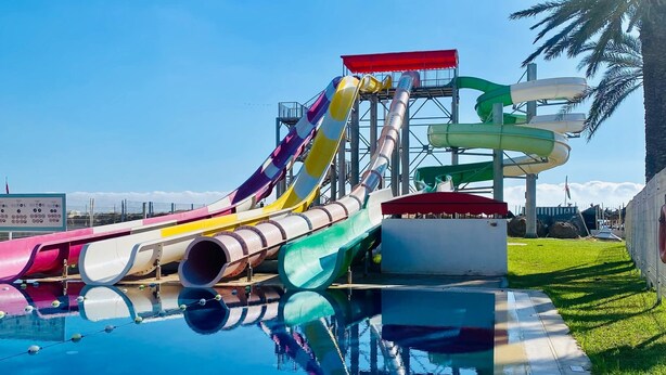 Un parque acuático con varias toboganes y una piscina.