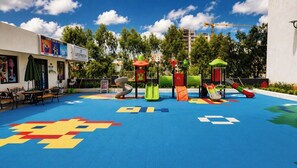 Un'area giochi all'aperto con scivoli e un pavimento colorato.