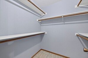 A corner of a room with white walls, wooden trim, and a tiled floor.