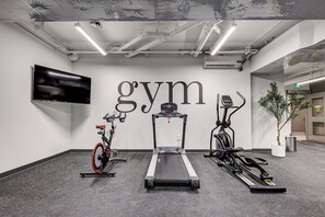 Ein Fitnessraum mit Laufband, Ergometer und Crosstrainer.