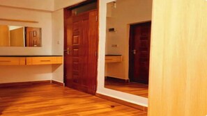 A room with wooden flooring, a wooden door, and a mirror on the wall. - Cozy Two bedroom apartment in Rossyn
This property is close to UN and VillageMkt (Nairobi)