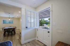 A room with a dining table and chairs, a white door with a window, and a ceiling light fixture. - Old Town Family 4BR Hot Tub Swing Set Office A+Loc (Scottsdale)