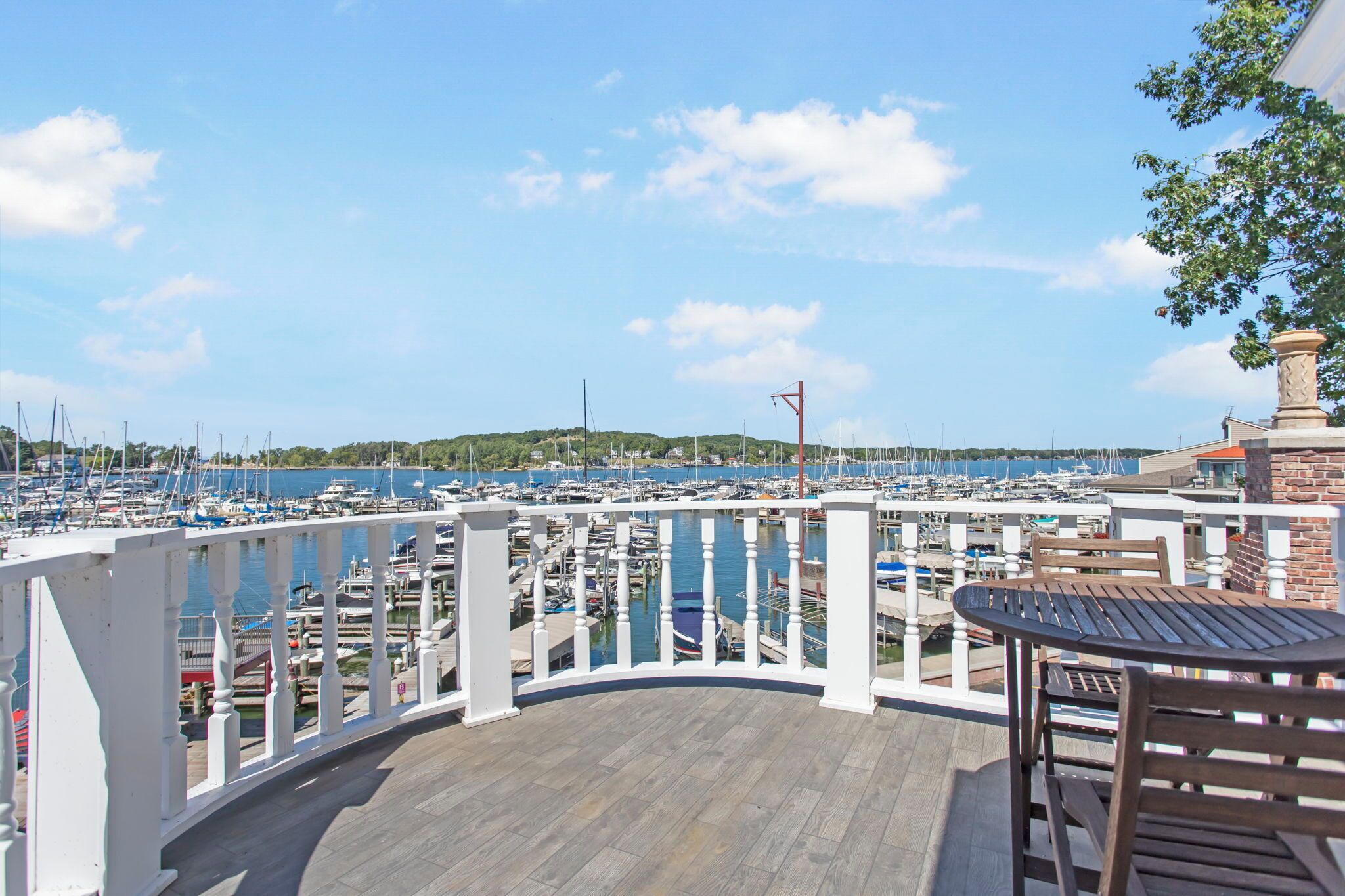 A marina with boats docked, a wooden deck, and a view of the water.