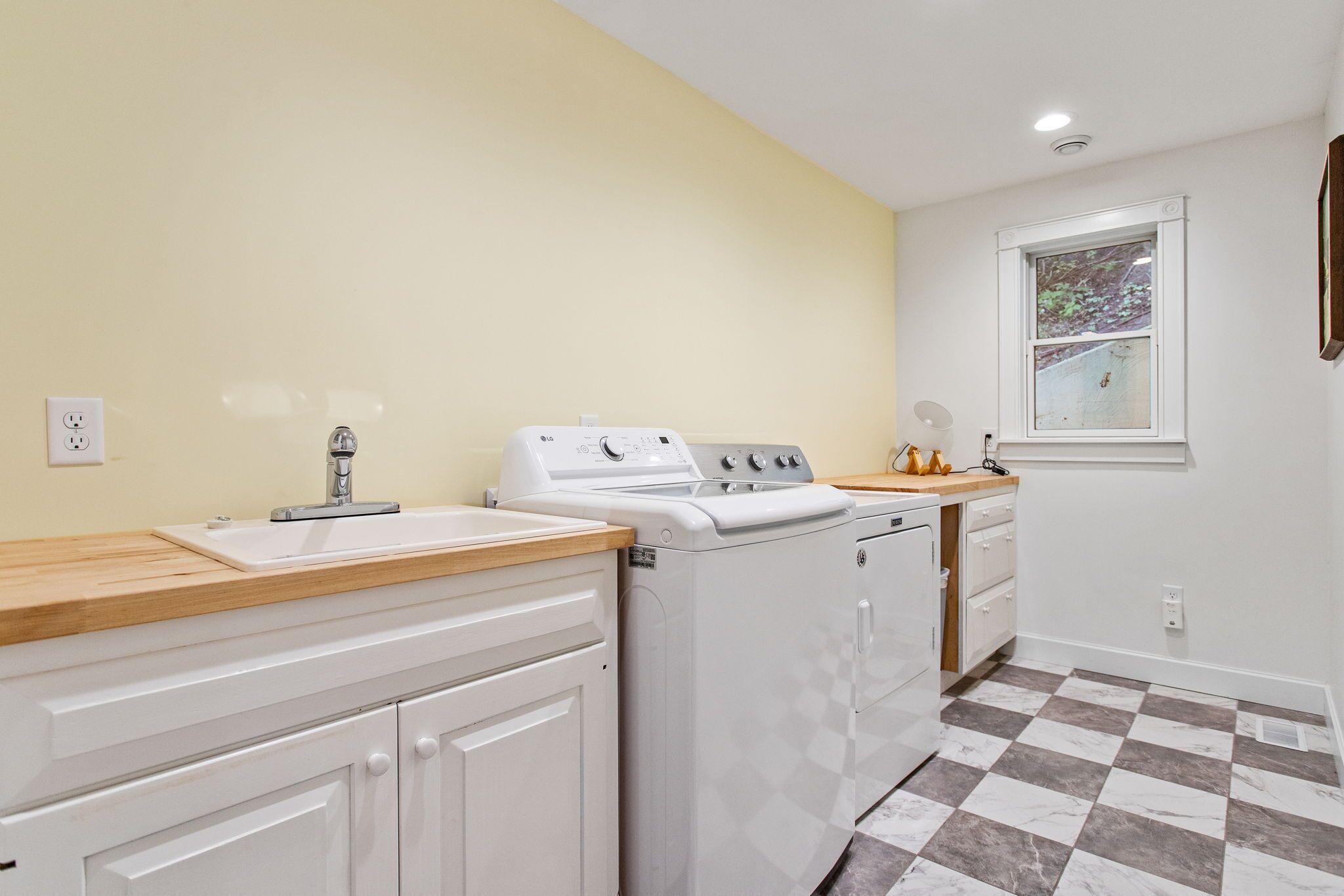 A compact kitchen with a sink, stove, and washing machine.