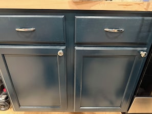 A set of dark blue cabinets with metallic handles, likely part of a kitchen or storage area.