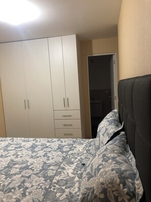 Ein Schlafzimmer mit einem Bett, einem Kleiderschrank und einer Tür zum Badezimmer.