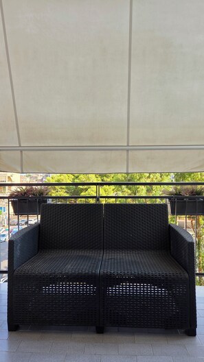 A black woven sofa under a white canopy, with a view of a street and greenery in the background. - For your vacation in Catania, just a few hundred meters from downtown. (Catania)