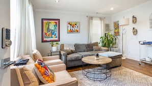 A modern living room with a sofa, armchair, and coffee table. - Lovely 2-bedroom condo with parking near H Street / Union Market (Washington)