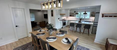 A modern kitchen with white cabinets, a central island, and pendant lighting.