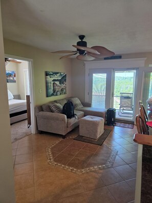 A living room with a sofa, ottoman, and a ceiling fan. - Family Lakeside Retreat in Jamestown! (Jamestown)