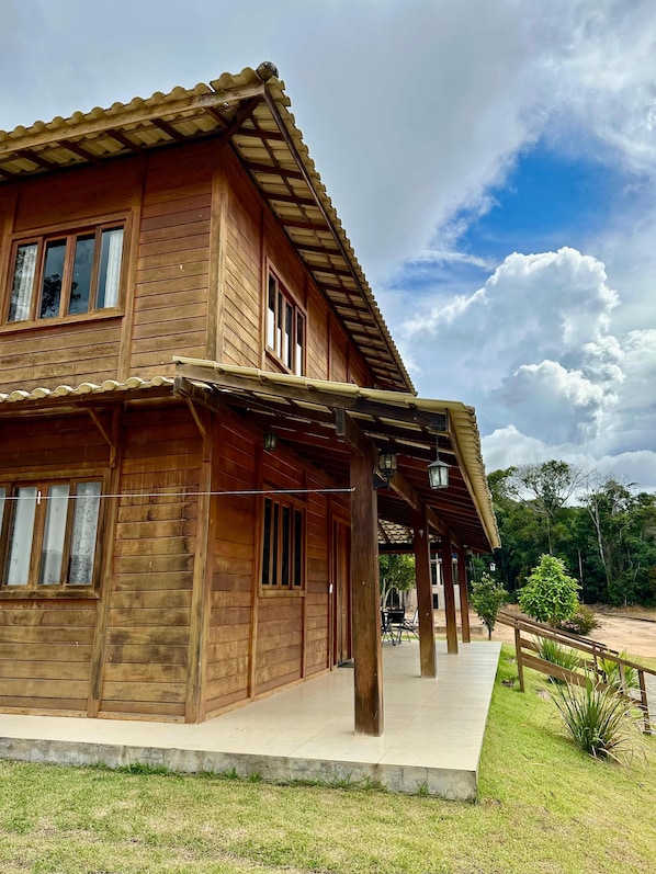 A wooden house with a covered porch and a view of the surrounding landscape.