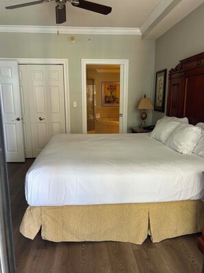 A bedroom with a large bed, a ceiling fan, and a door leading to another room. - Beautiful condo with amazing view located in Emerald Grande at the Harborwalk. (Destin)