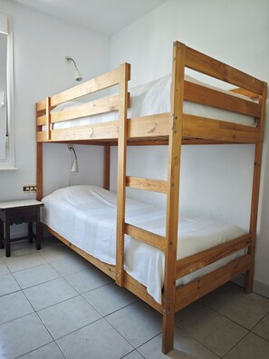 A bunk bed with a desk and lamp, in a room with tiled flooring. - Two-story house in P. Andaluz/Torróx Costa. 3 bedrooms, sleeps 5, and community pool (Torróx Costa)