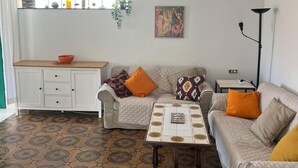 Ein Wohnzimmer mit einer Couch, einem Couchtisch, einem Schrank und einem gemusterten Boden.
