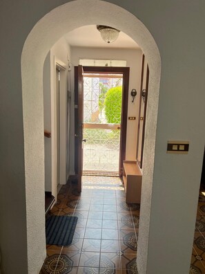 A hallway with patterned tiles, a door leading outside, and a small bench. - Two-story house in P. Andaluz/Torróx Costa. 3 bedrooms, sleeps 5, and community pool (Torróx Costa)