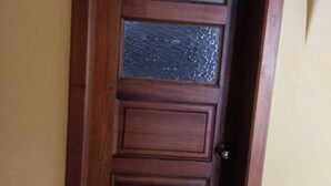 Una puerta de madera con un panel de vidrio y un picaporte de metal.