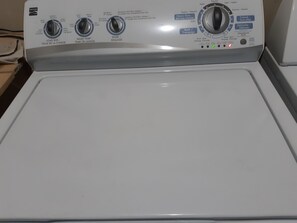 Vue de face d’un lave-linge Kenmore doté de plusieurs boutons de commande et de différents réglages.