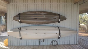 Two surfboards mounted on a wall in a covered area with a wooden deck. - 4 bedroom beach front beach house (Alligator Point)