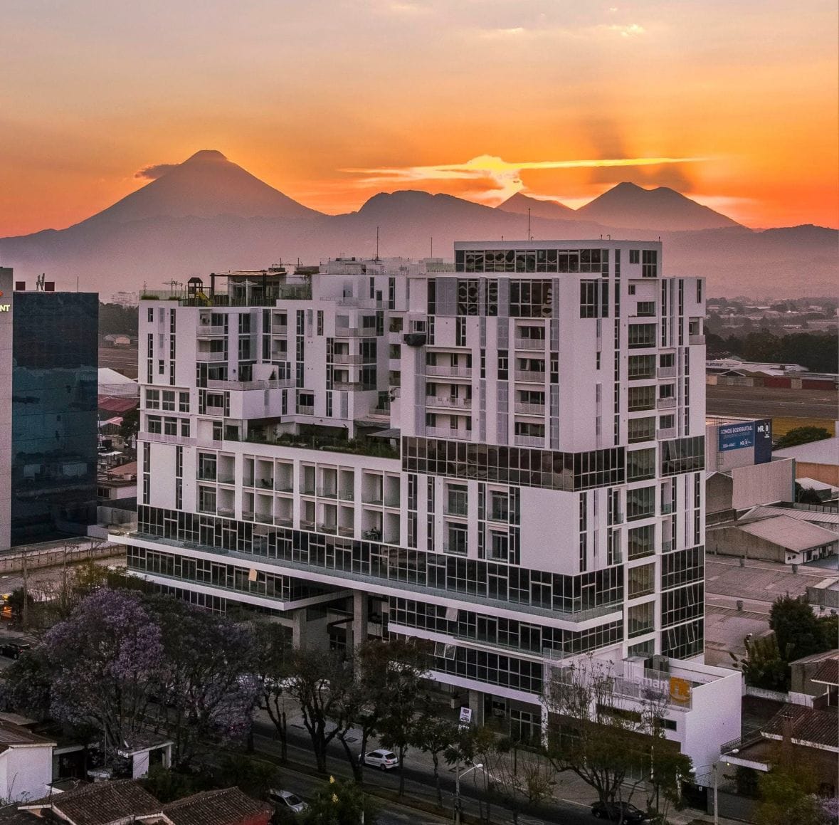 A multi-story building with a modern architectural design, featuring a mix of glass and concrete facades.