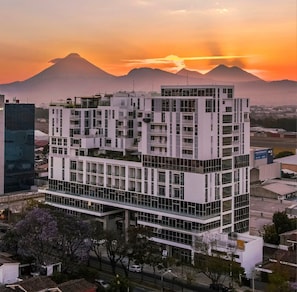 A multi-story building with a modern architectural design, featuring a mix of glass and concrete facades.