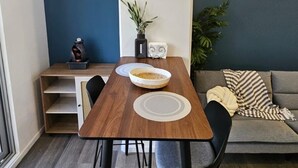 Un espacio habitable compacto con una mesa de comedor, sillas, un sofá y una mesita auxiliar con adornos.