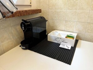 A coffee machine and a box of coffee capsules on a countertop. - Apartment with a 150-square-meter Private Terrace and Breathtaking Lake Views (Trentino-Alto Adige)