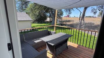 A covered outdoor deck with a built-in seating area and a view of the surrounding landscape.