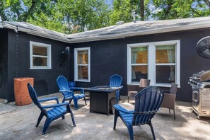 A patio with outdoor furniture, a grill, and a fan.