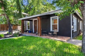 A single-story house with a covered porch, a small patio, and a seating area with two chairs. - Chef`s Kitchen + Fire Pit Patio | E Austin Bungalow Mins to Local Favs & Lady Bird (Austin)