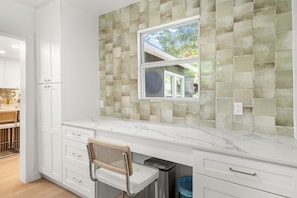 A kitchen with white cabinetry, a marble countertop, and a backsplash with square tiles. - Chef`s Kitchen + Fire Pit Patio | E Austin Bungalow Mins to Local Favs & Lady Bird (Austin)