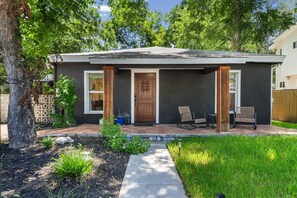 A single-story house with a front porch, a wooden door, and two rocking chairs. - Chef`s Kitchen + Fire Pit Patio | E Austin Bungalow Mins to Local Favs & Lady Bird (Austin)