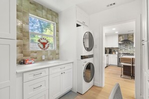 A modern kitchen with built-in appliances, a large window, and a view of the outdoors. - Chef`s Kitchen + Fire Pit Patio | E Austin Bungalow Mins to Local Favs & Lady Bird (Austin)