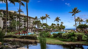 Un resort con piscina, palmeras y un edificio de varios pisos.