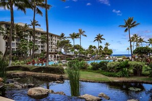 A resort with a pool, palm trees, and a building with multiple floors. - Oceanfront Christmas Week Studio with all luxury resort amenities. (Lahaina)