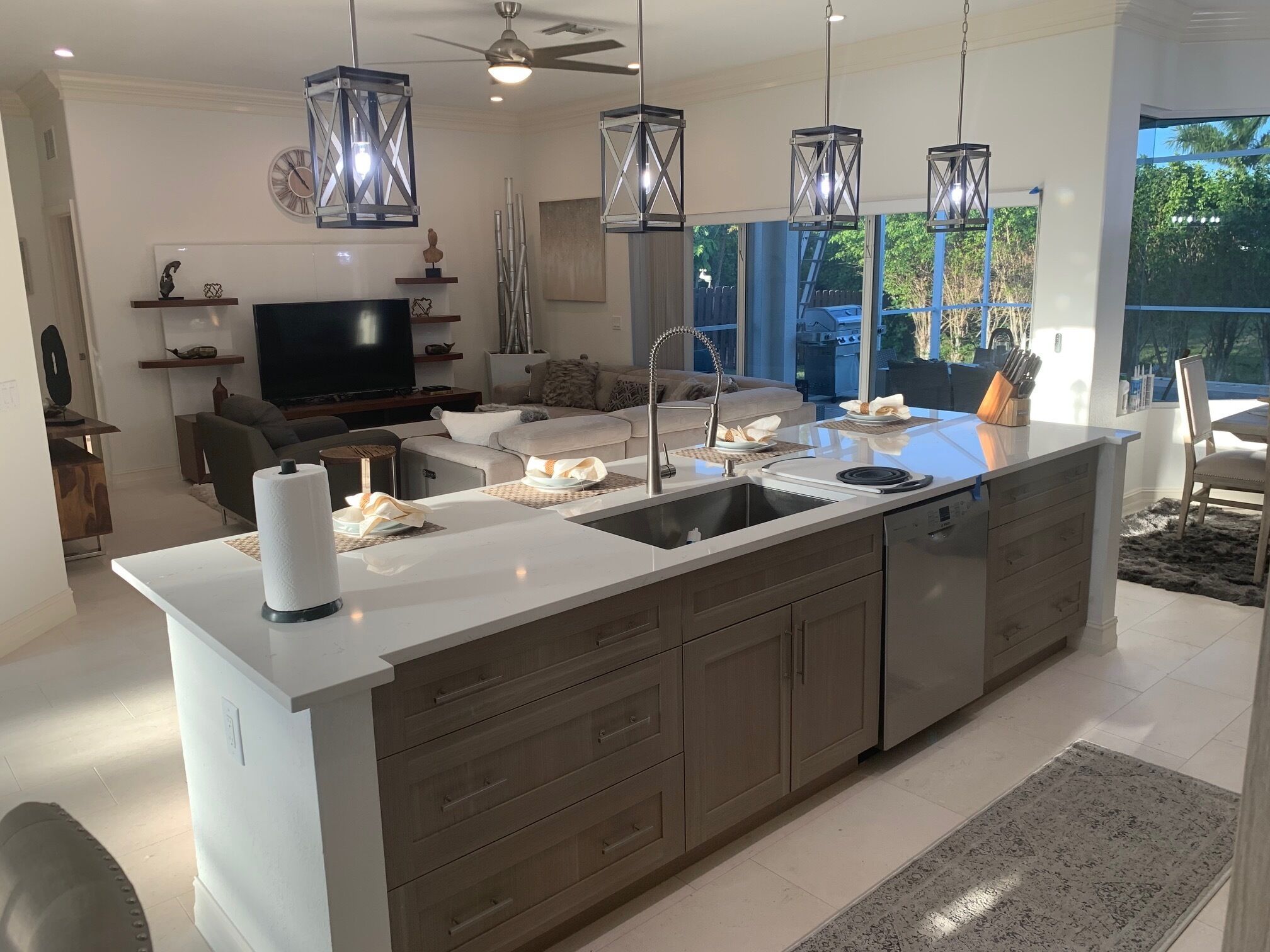 A modern kitchen with a central island, stainless steel appliances, and pendant lighting.